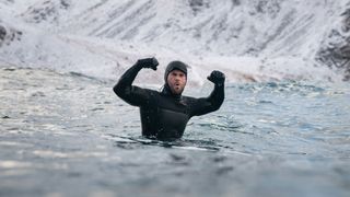 Chris Hemsworth celebrates while surfing.