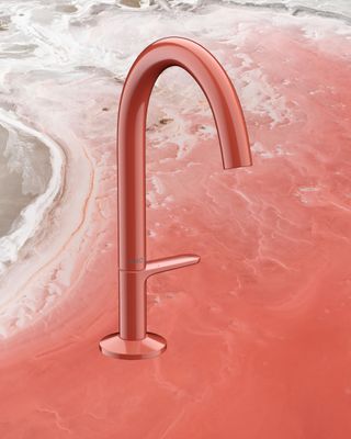 Red tap on background of red sandy beach with waves