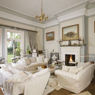 living room with white walls fireplace and sofa set with cushions