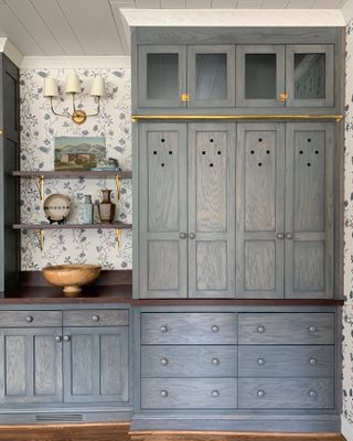 a grey-blue stained kitchen cabinet with wallpaper