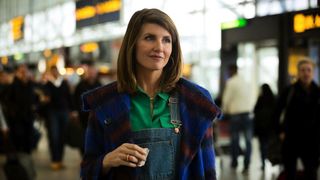 Sharon Morris (Sharon Horgan), holding a piece of paper while standing in an airport, in 'Catastrophe.'