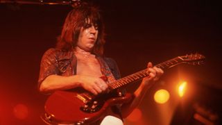 Pat Travers plays a red double cut electric guitar as he performs onstage at the Aragon Ballroom, Chicago, Illinois, October 19, 1979