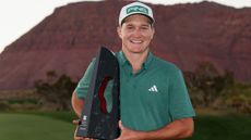 Matt McCarty holds up the 2024 Black Desert Championship trophy