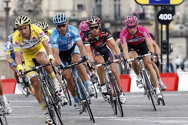 The peloton rides in Paris at high speeds.