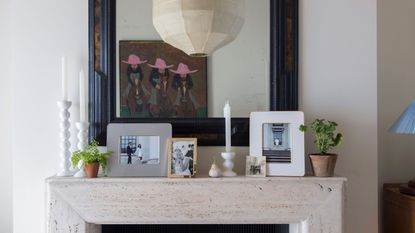 Frames on a stone fireplace with a mirror above