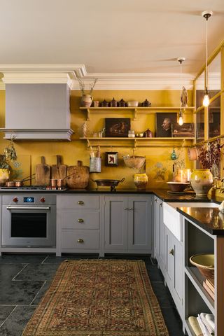 An eclectic yellow kitchen with painted yellow crittall windows on one side