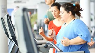 Woman running on a treadmill with coach