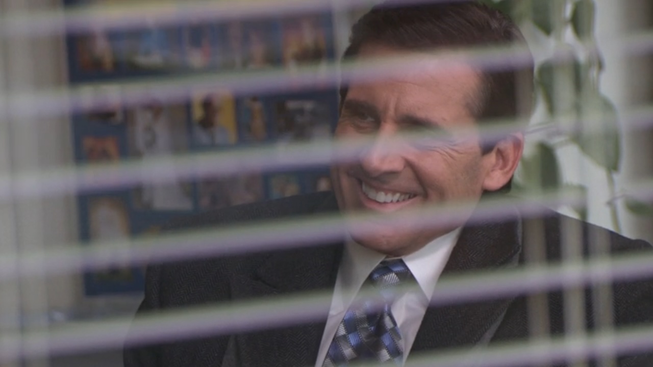 Michael sonríe a través de la ventana de la oficina.