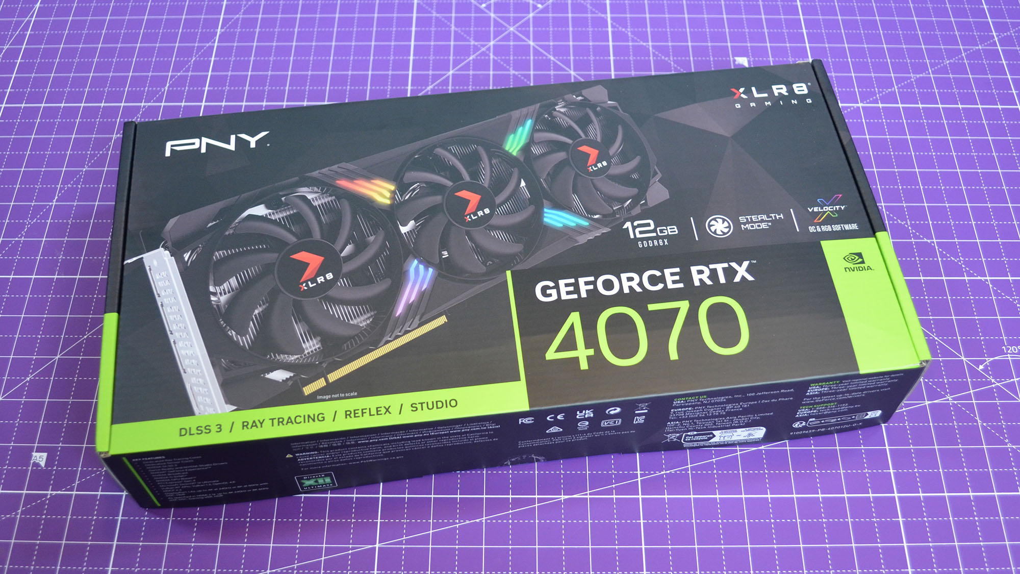 Eine PNY RTX 4070 XLR8 Gaming-Grafikkarte auf einer lila Schreibtischunterlage