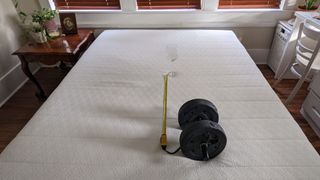 Bear Original mattress with a weight, wine glass and tape measure to show motion transfer test