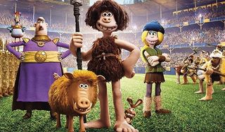 Early Man cast stands on the soccer pitch