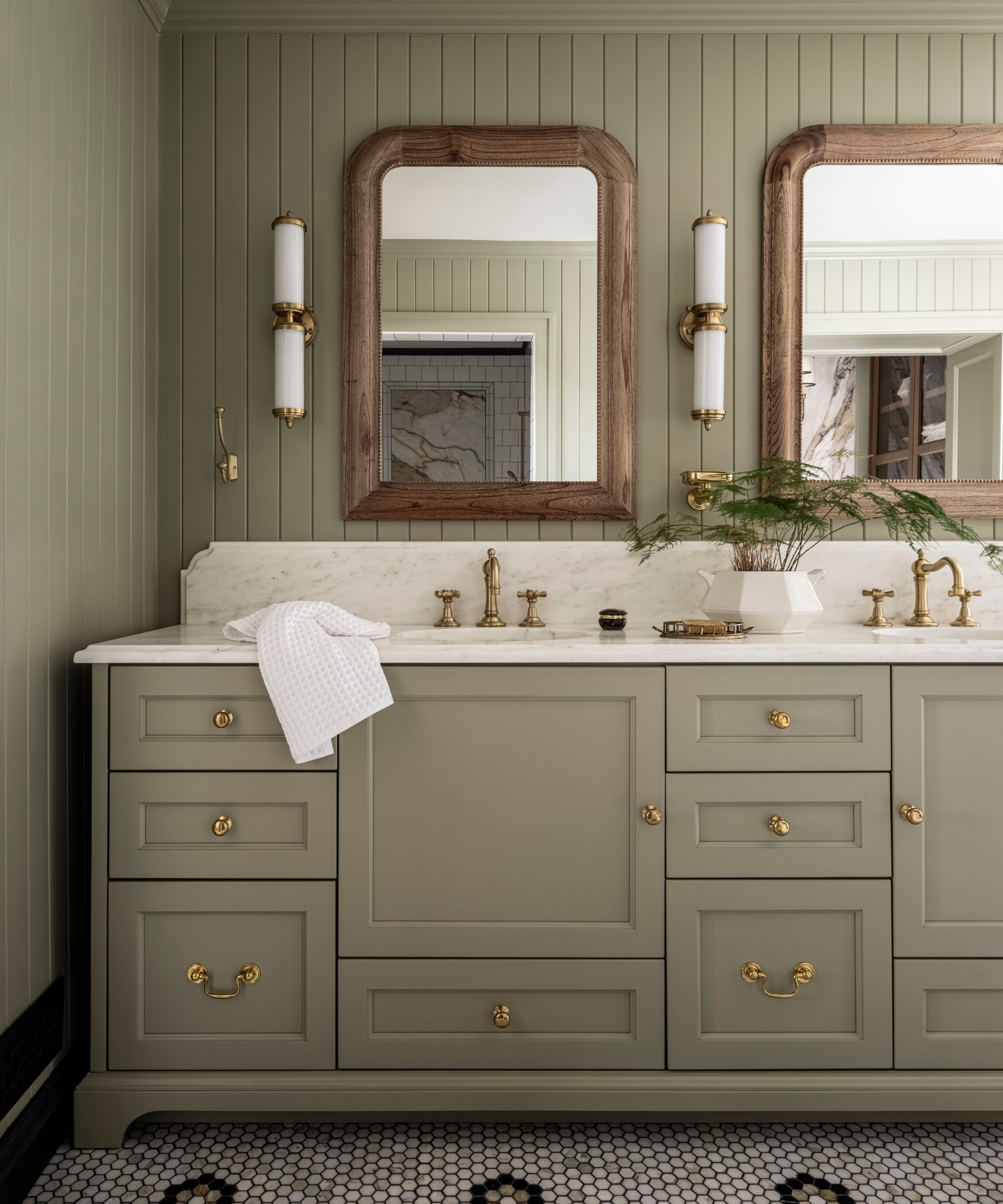 A country bathroom color drenched in soft green across the walls and vanity