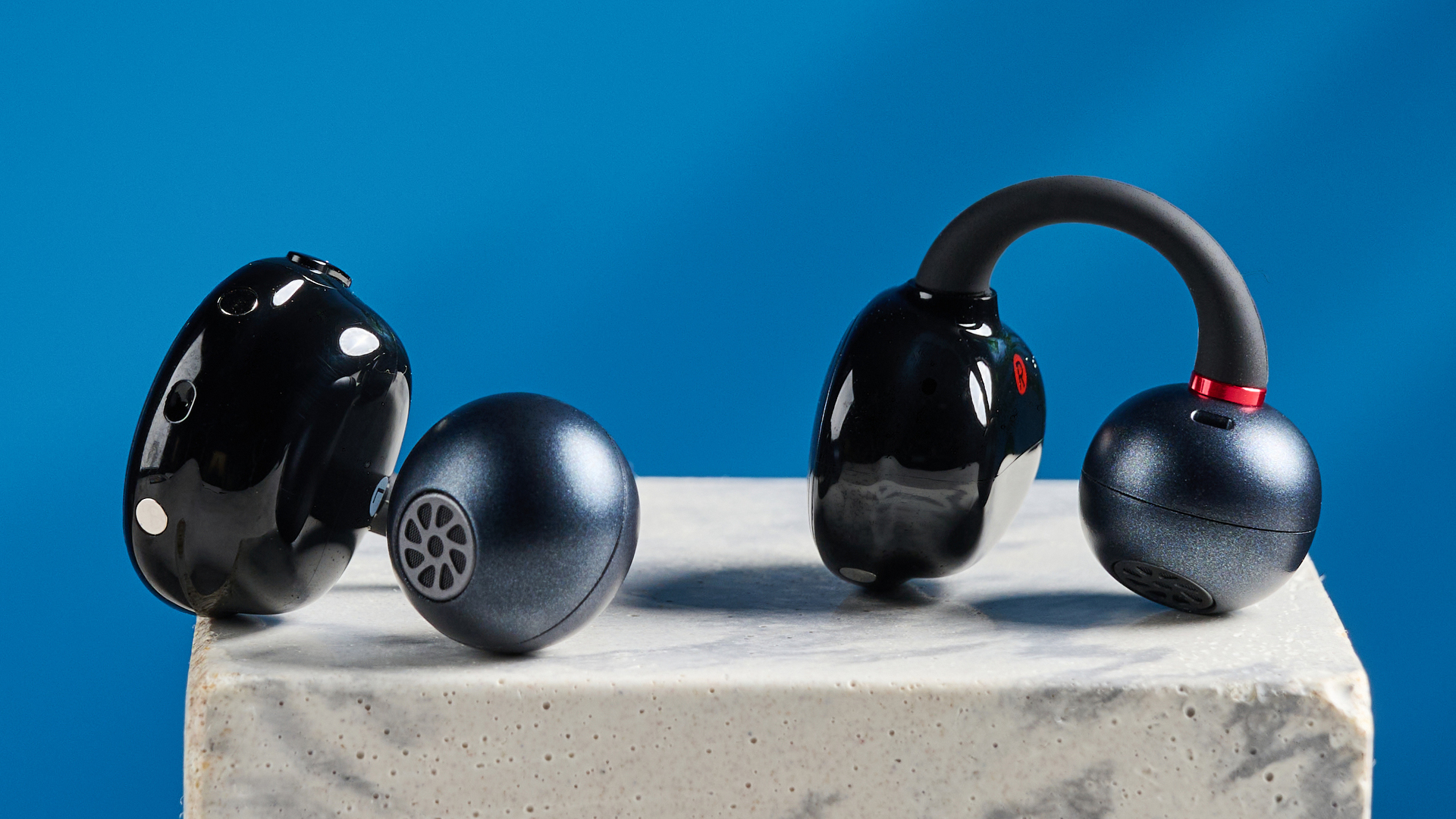 EarFun Clip open-earbuds photographed in front of a blue background.
