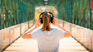 Black Friday headphones deals: The back of a woman adjusting her headphones