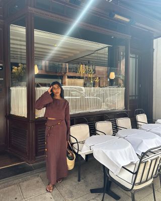 Woman infront of restaurant wears brown linen top and linen skirt