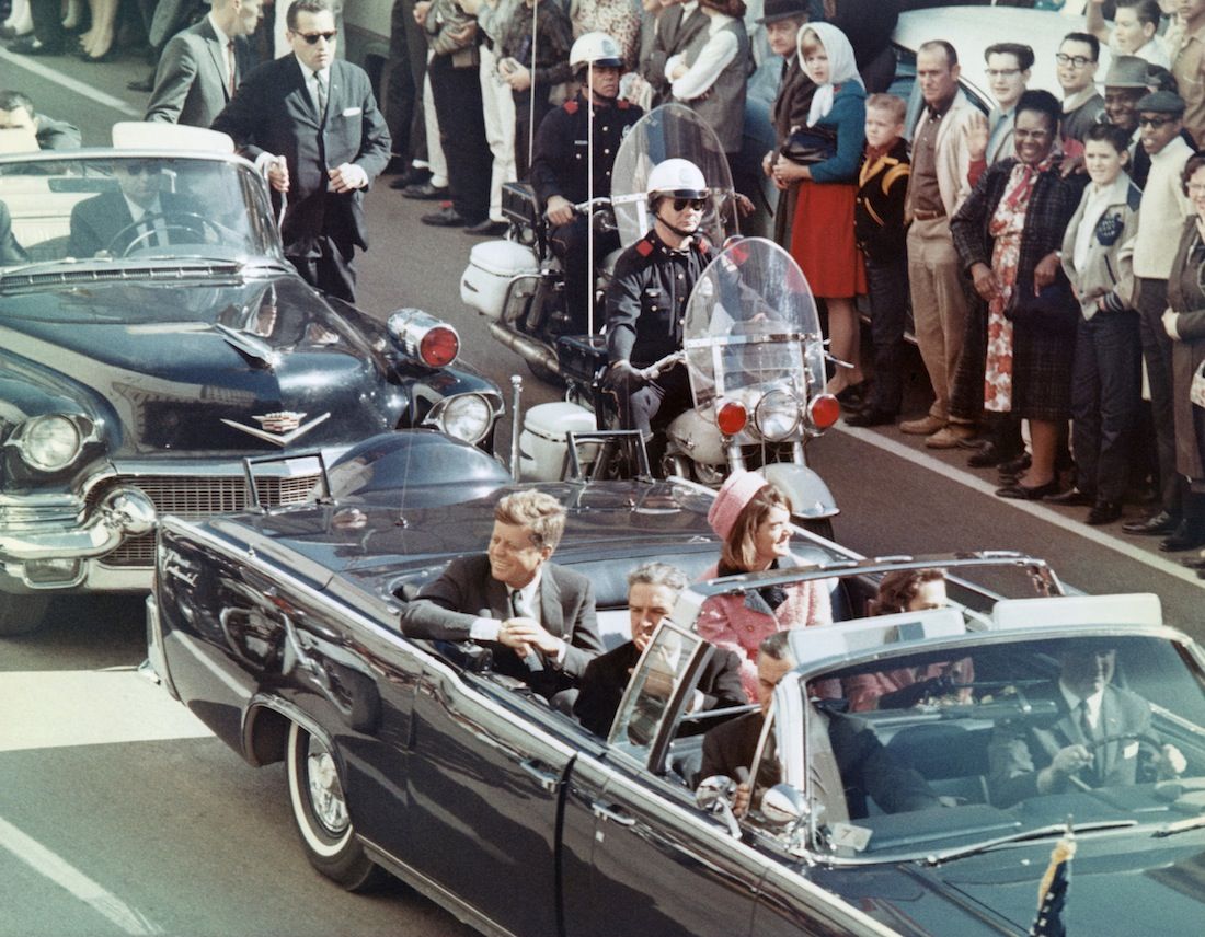 President and Mrs. John F. Kennedy smile at the crowds lining their motorcade route in Dallas, Texas, on November 22, 1963. Minutes later the President was assassinated as his car passed through Dealey Plaza.