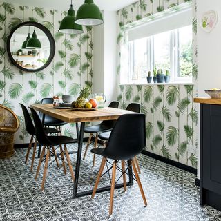 dark grey units and palm print wallpaper in kitchen diner area