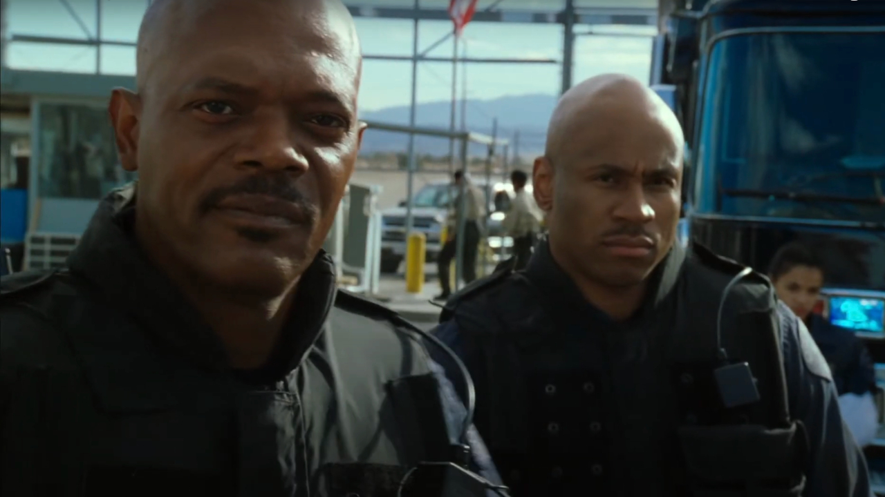 Samuel L Jackson looks ahead with determination as LL Cool J watches in SWAT.