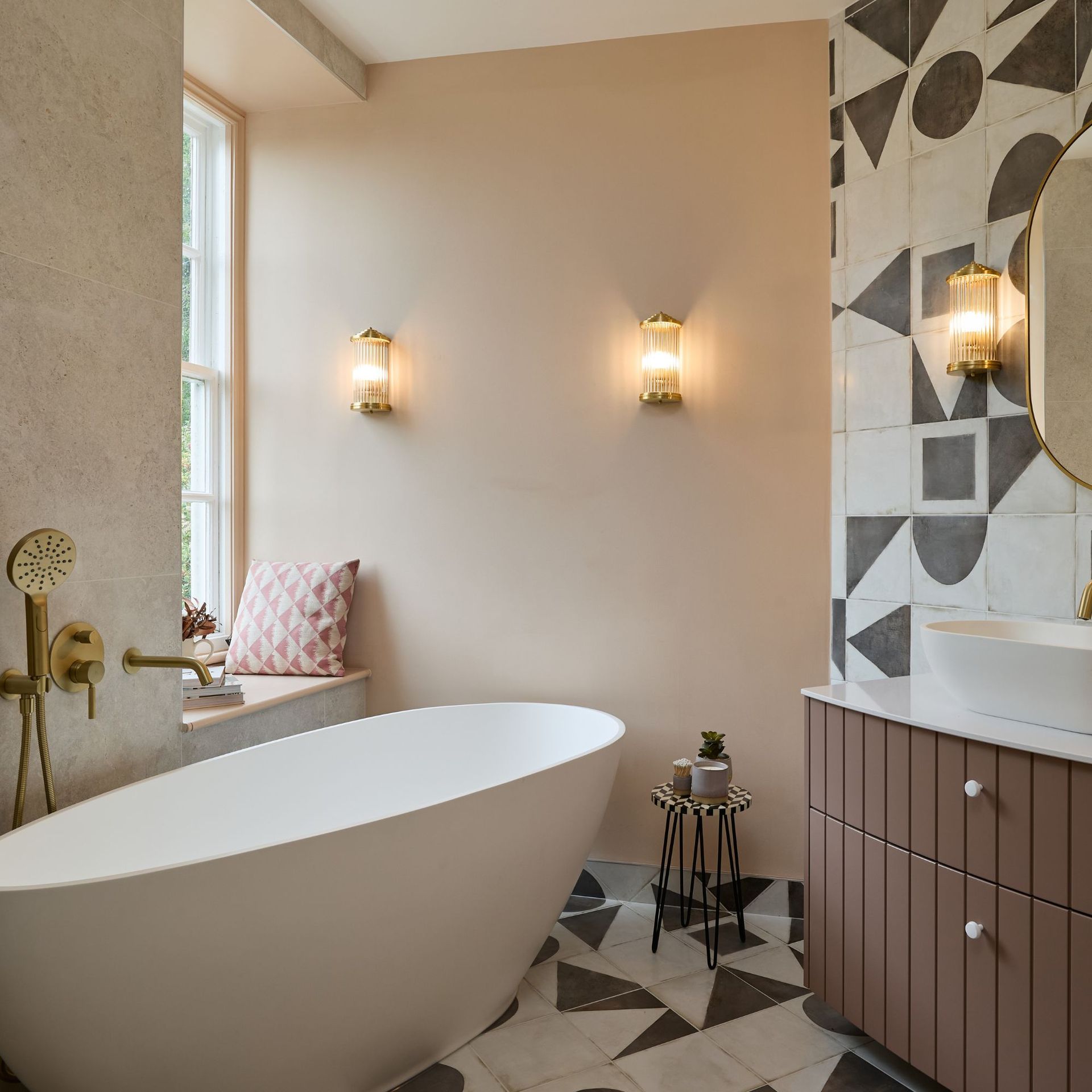 Neutral bathroom with pale pink walls, large freestanding tub and vanity unit