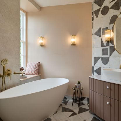 Neutral bathroom with pale pink walls, large freestanding tub and vanity unit