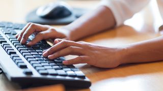 Person typing on keyboard