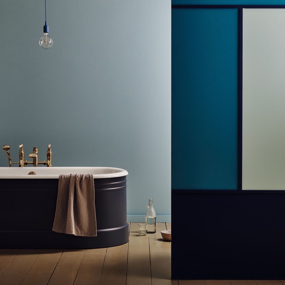 bathroom with navy blue bathtub and wooden floor