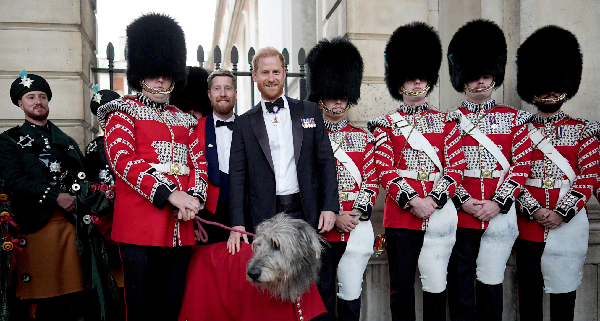 Prince Harry posing with the Irish Guards band and their mascot dog, Seamus