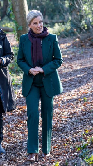 Sophie, Duchess of Edinburgh walks into the woodland area to plant some seeds, plant a tree with the tree Wardens and meet children from the Forest School by a camp fire during her visit to Community Projects at Burwell Hall on January 18, 2024 in Walton-on-Thames, England.