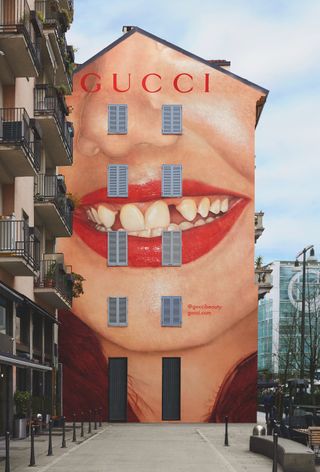 large painting of red lips on the side of a building