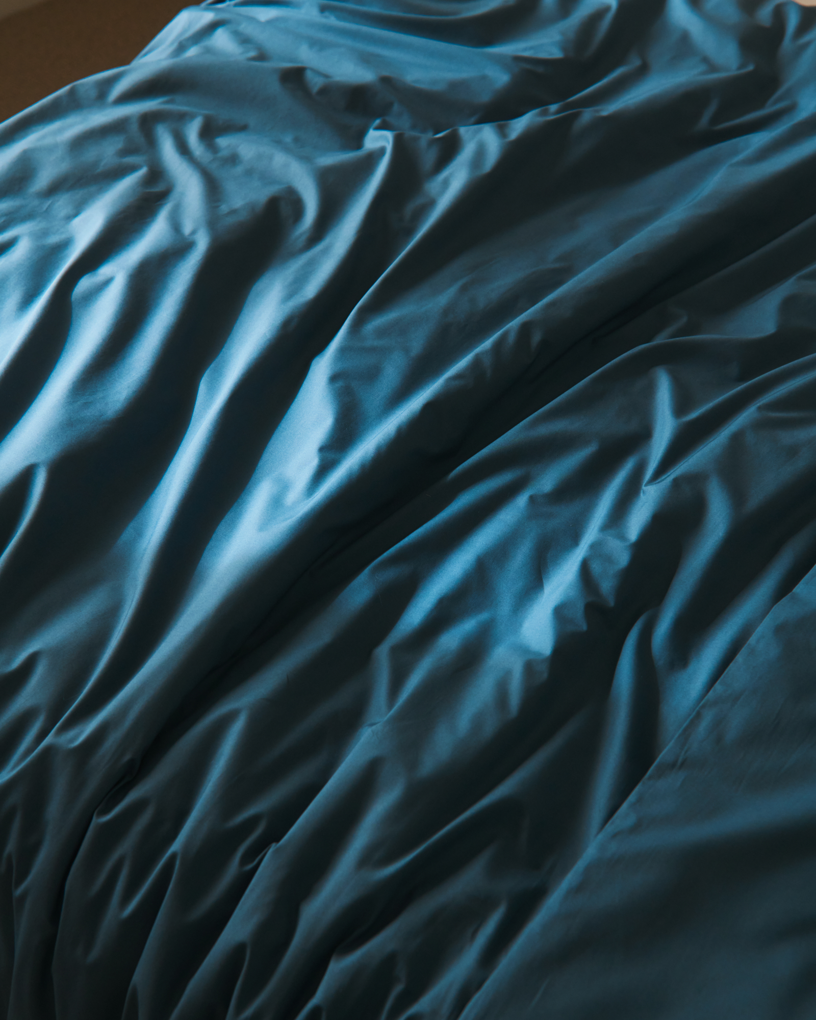 Close up image of wrinkled dark teal sheets