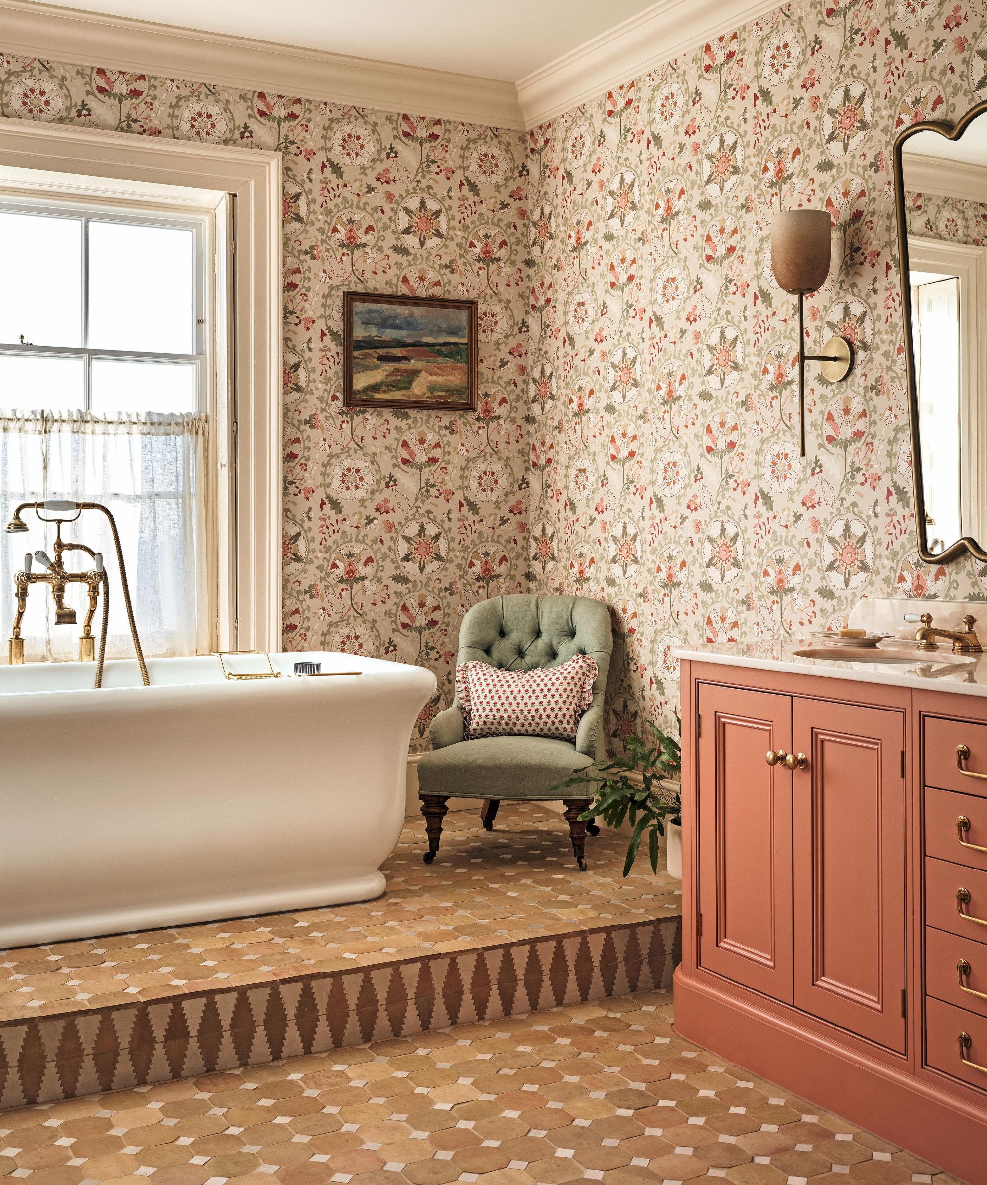 the main bathroom in a large english home with terracotta floor tiles, a freestanding tub, wallpapered walls and a pink painted vanity
