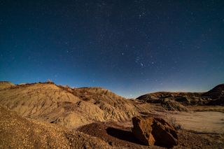 bright stars in the night sky above a desert