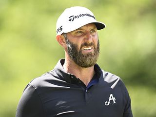 Dustin Johnson in a black polo shirt and white hat