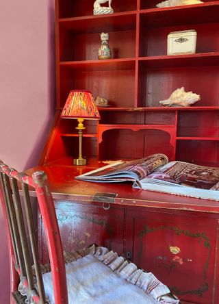 red desk unit with desk lamp with red patterned fabric shade