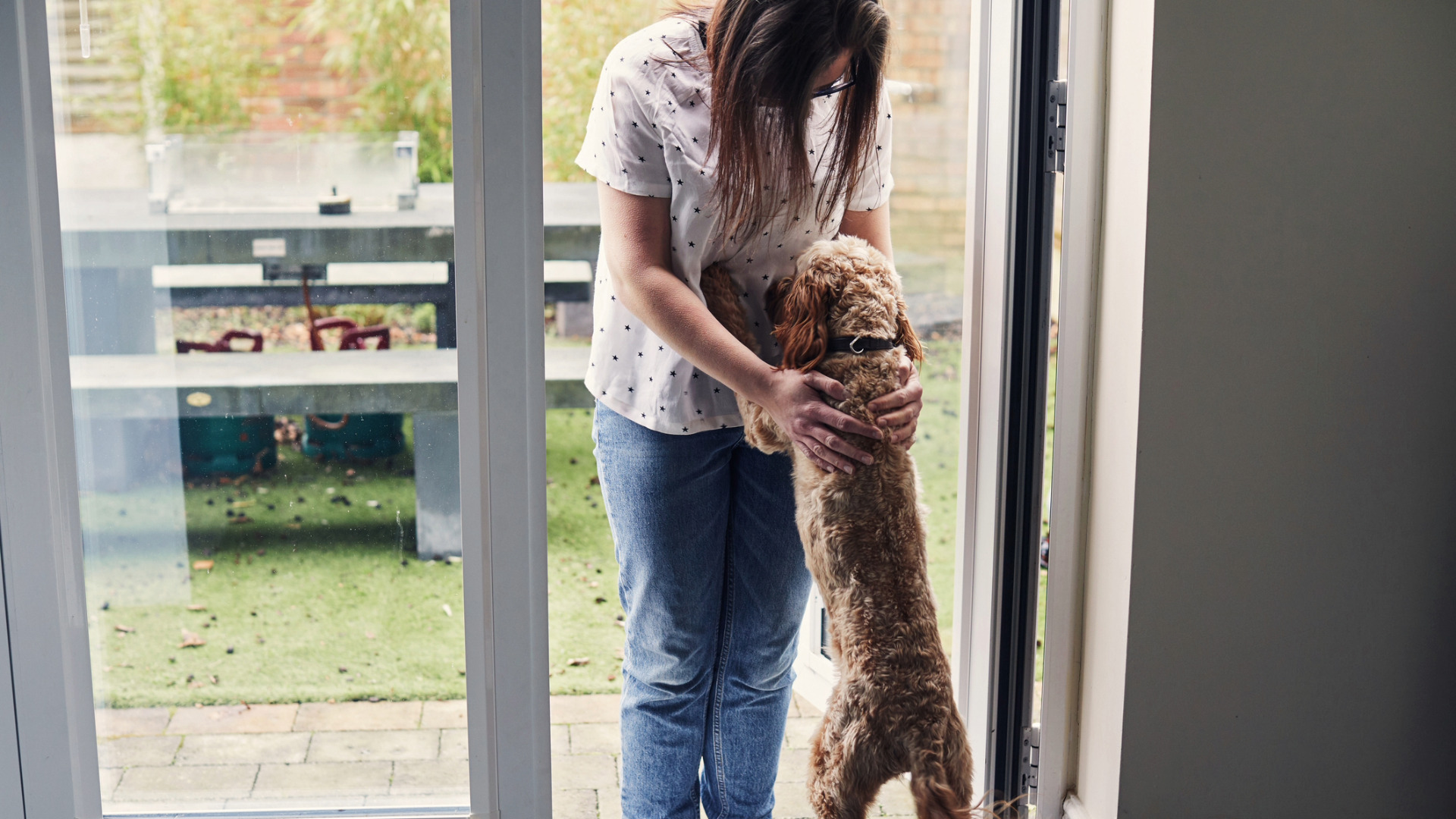 dog excitedly greets woman at door