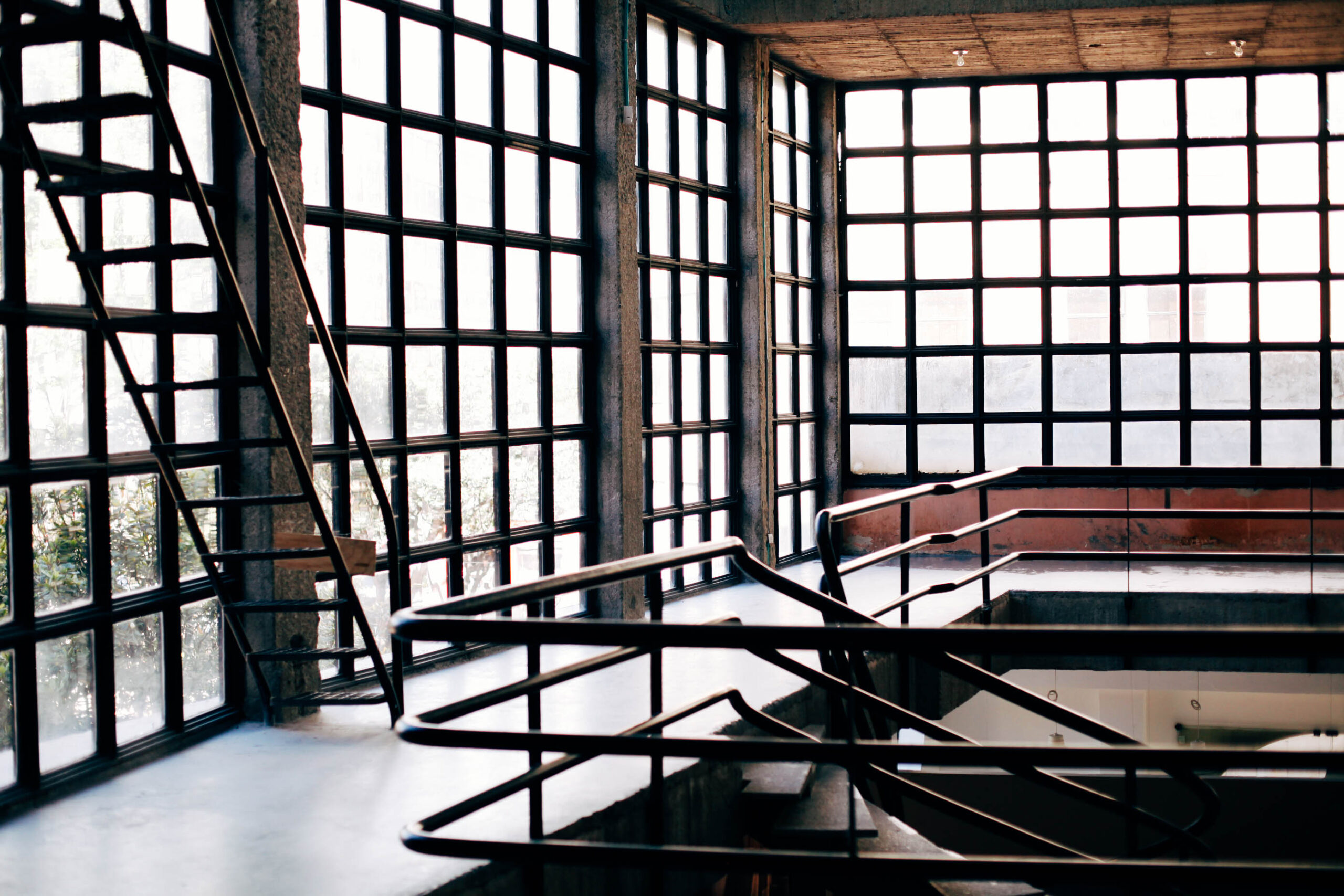 The bones of an old warehouse, with floor-to-ceiling checkered windows and exposed cement.