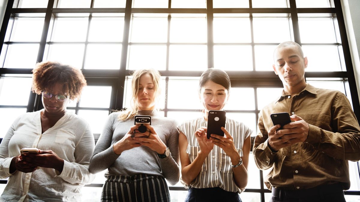 Millennials in a circle looking at phones.