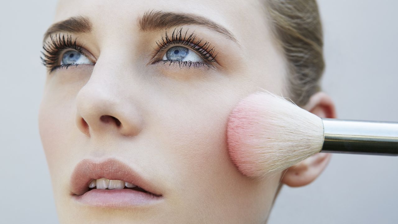 Studio shot of female model and pink blusher brush