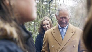 King Charles III in a brown coat walks around the Dumfries House Estate in A Royal Grand Design.