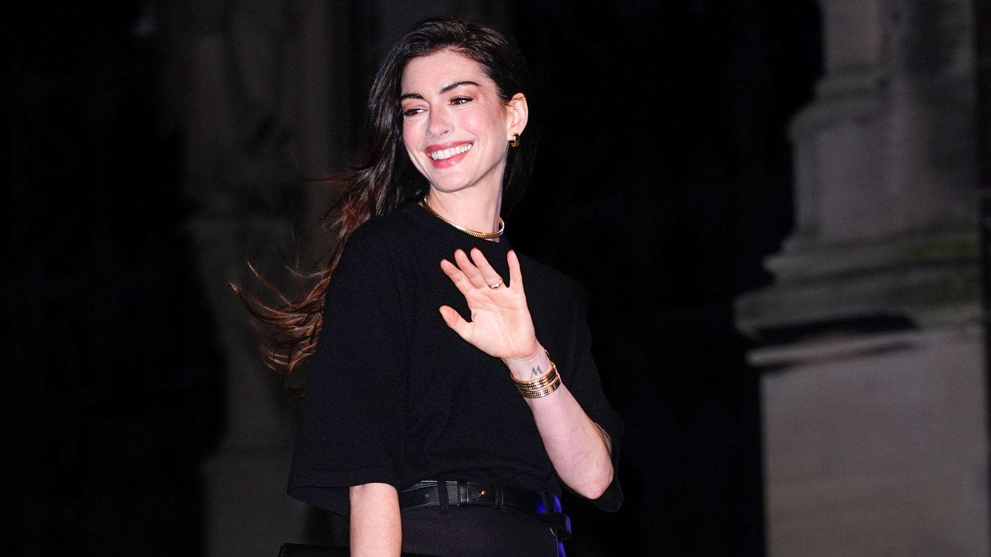 Anne Hathaway smiles and waves