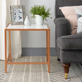 marble top table with plant pot and sofa