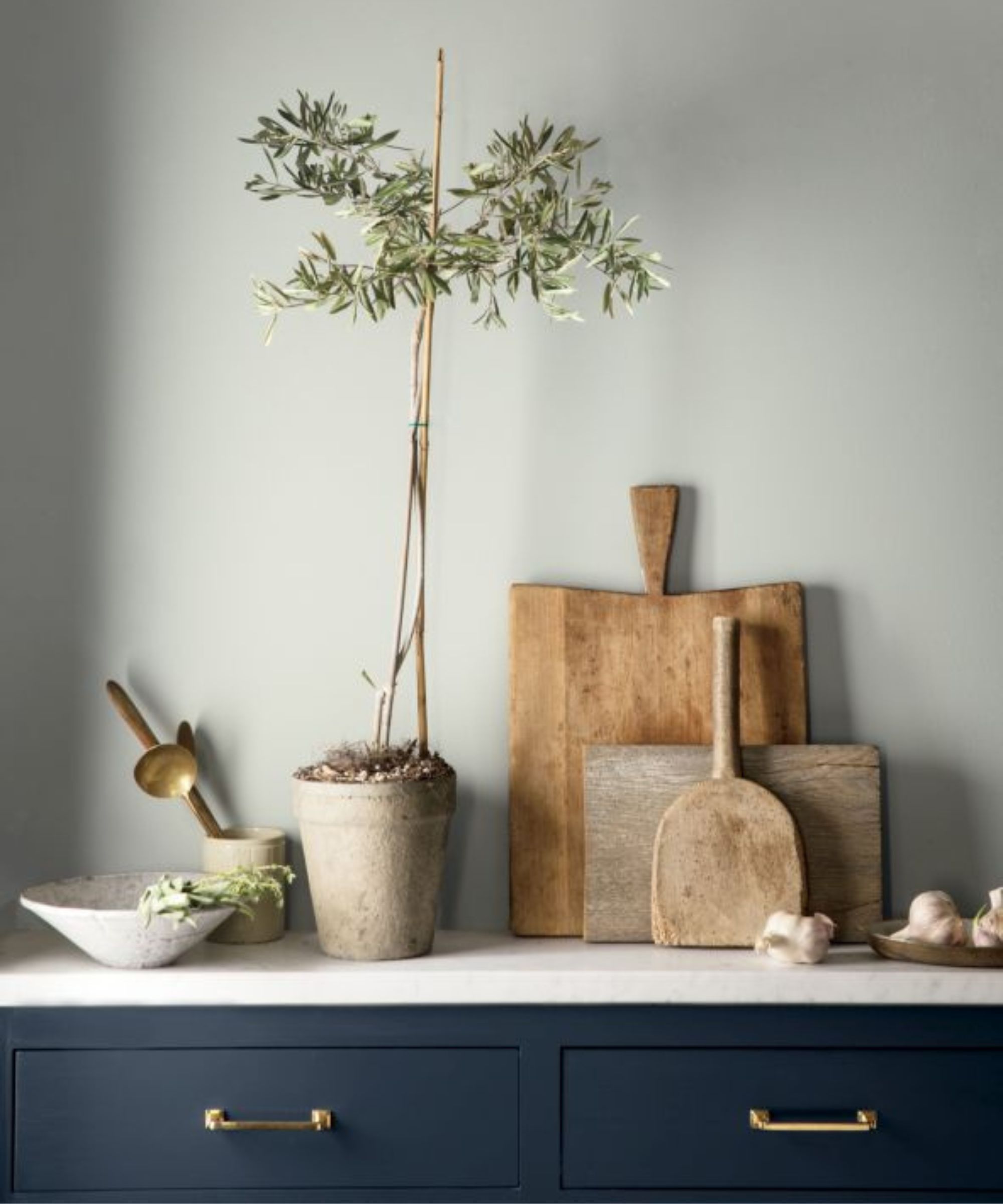 navy blue kitchen cabinetry with white countertops and wooden cutting boards