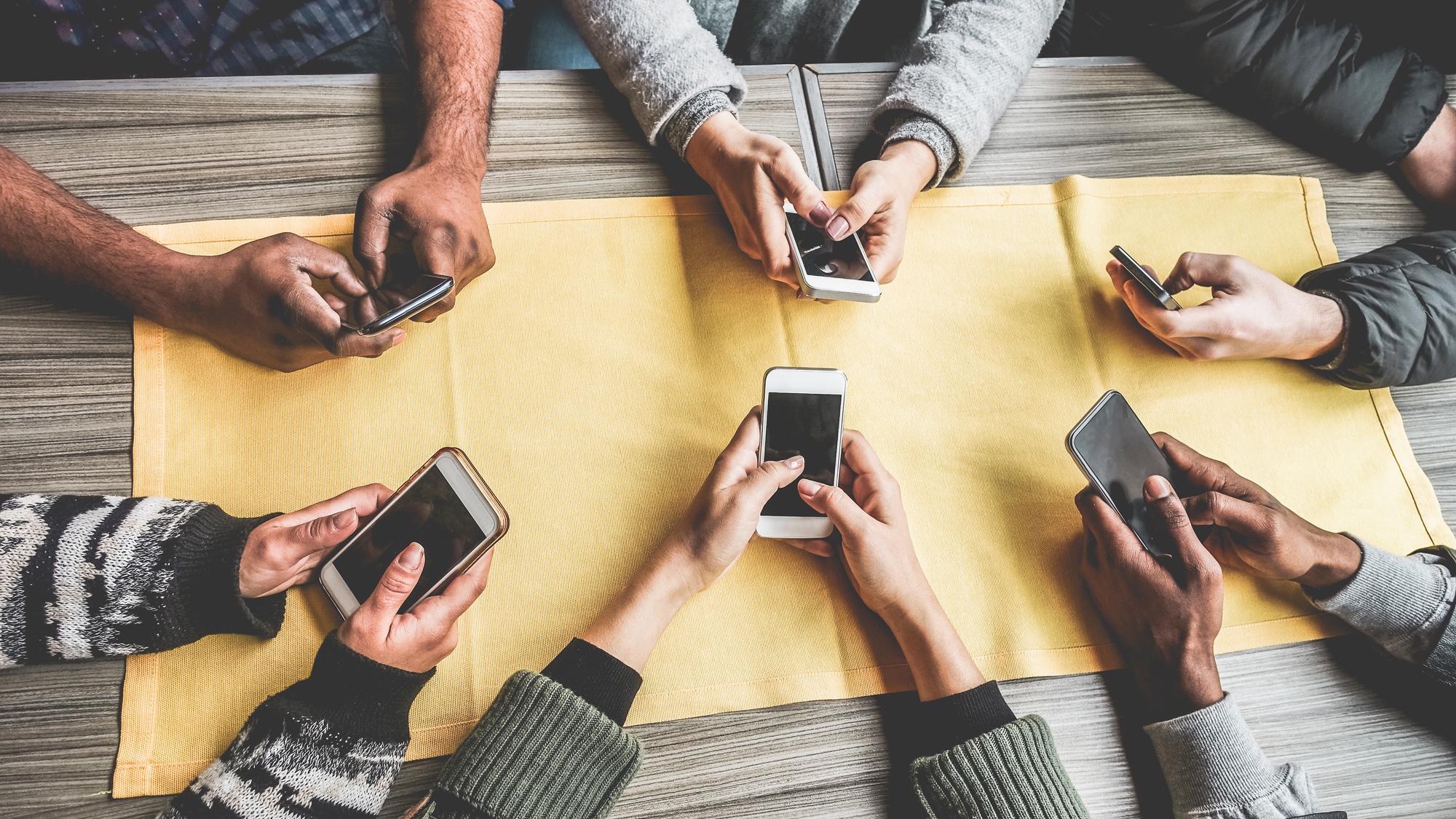 six people holding cell phones