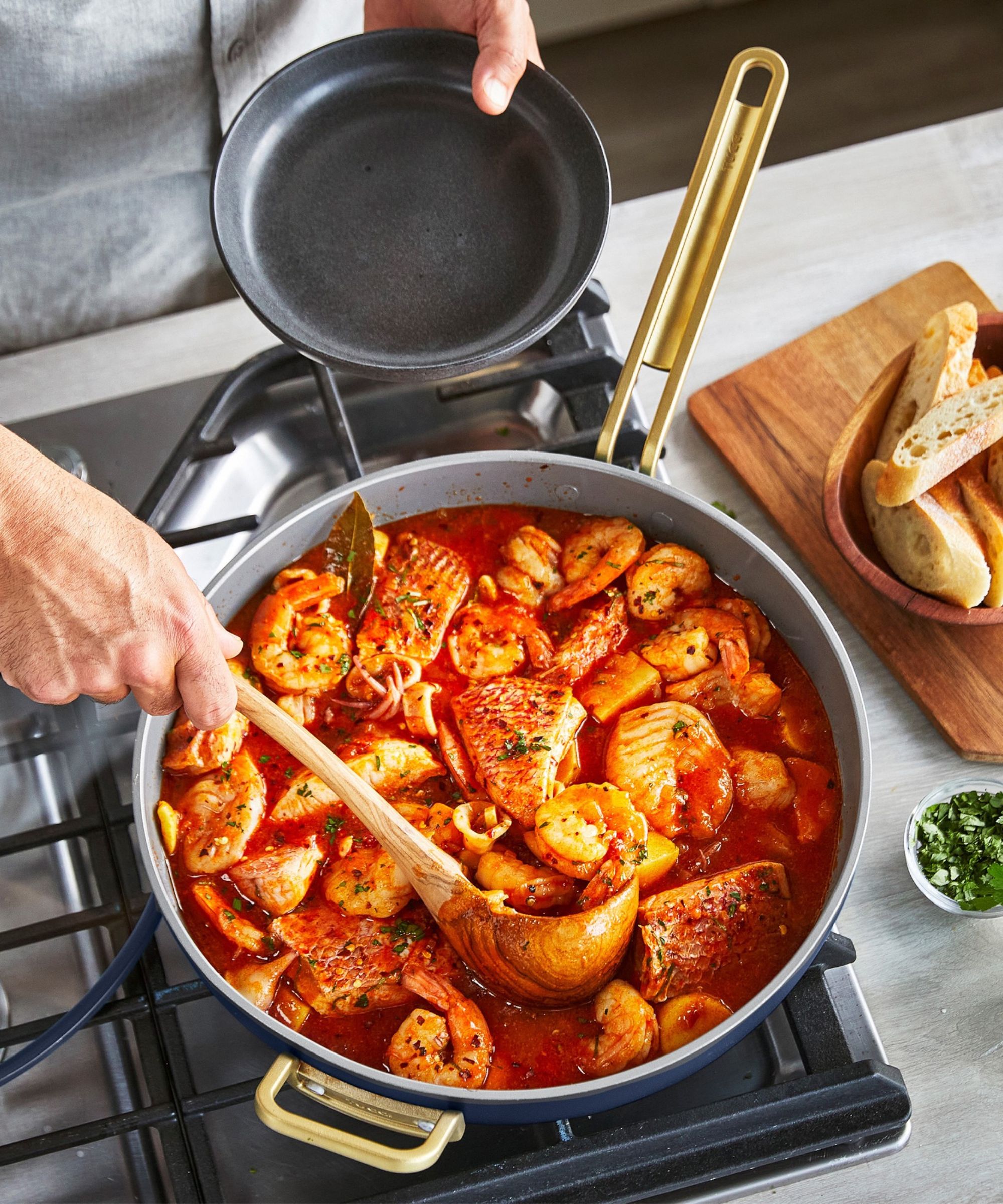 Teal frying pan containing a seafood stew