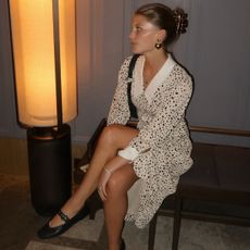 Influencer Laure Elson wears a polka dot dress and Reformation flats. She swears Blinker and Eliza heart earrings. 