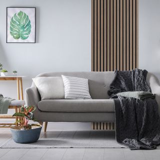 White living room with wooden wall panel feature behind grey sofa
