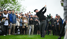 Rory McIlroy hits a wedge shot out of the rough