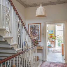 landing in a georgian village with decorative balustrades, ornate cornicing and view through to room with large sash windows
