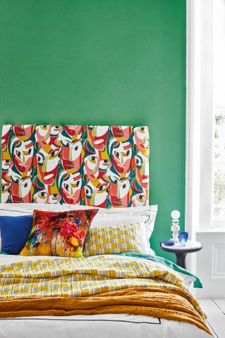 Green bedroom with patterned headboard