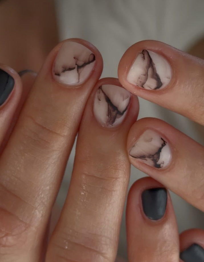 milky nails with smoky brown marble swirls mixed with solid dark gray polish